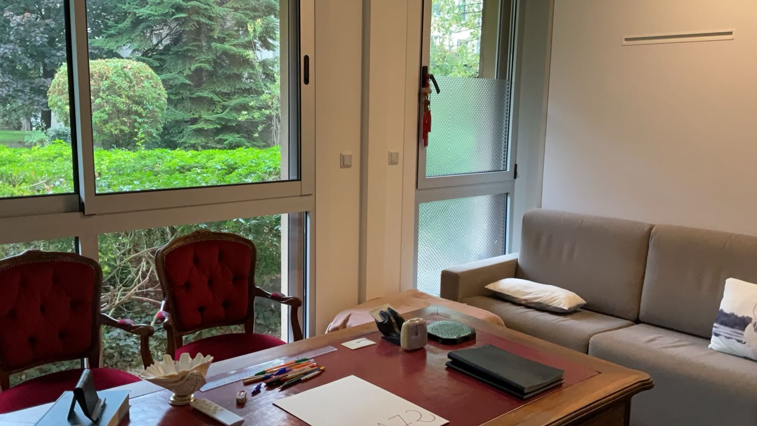 Bureau et fauteuils du cabinet de psychanalyse aux Lilas, lumière des arbres